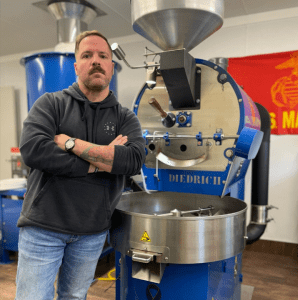 Sam Floyd by his coffee roaster.