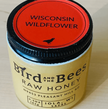 6.5 ounce glass jar of Raw Honey by Bird and the Bees Apiary in Iola Wisconsin. The Flavor is Wisconsin Wildflower, it gives warm spice notes and a fruity finish thanks to local wisconsin wildflowers.