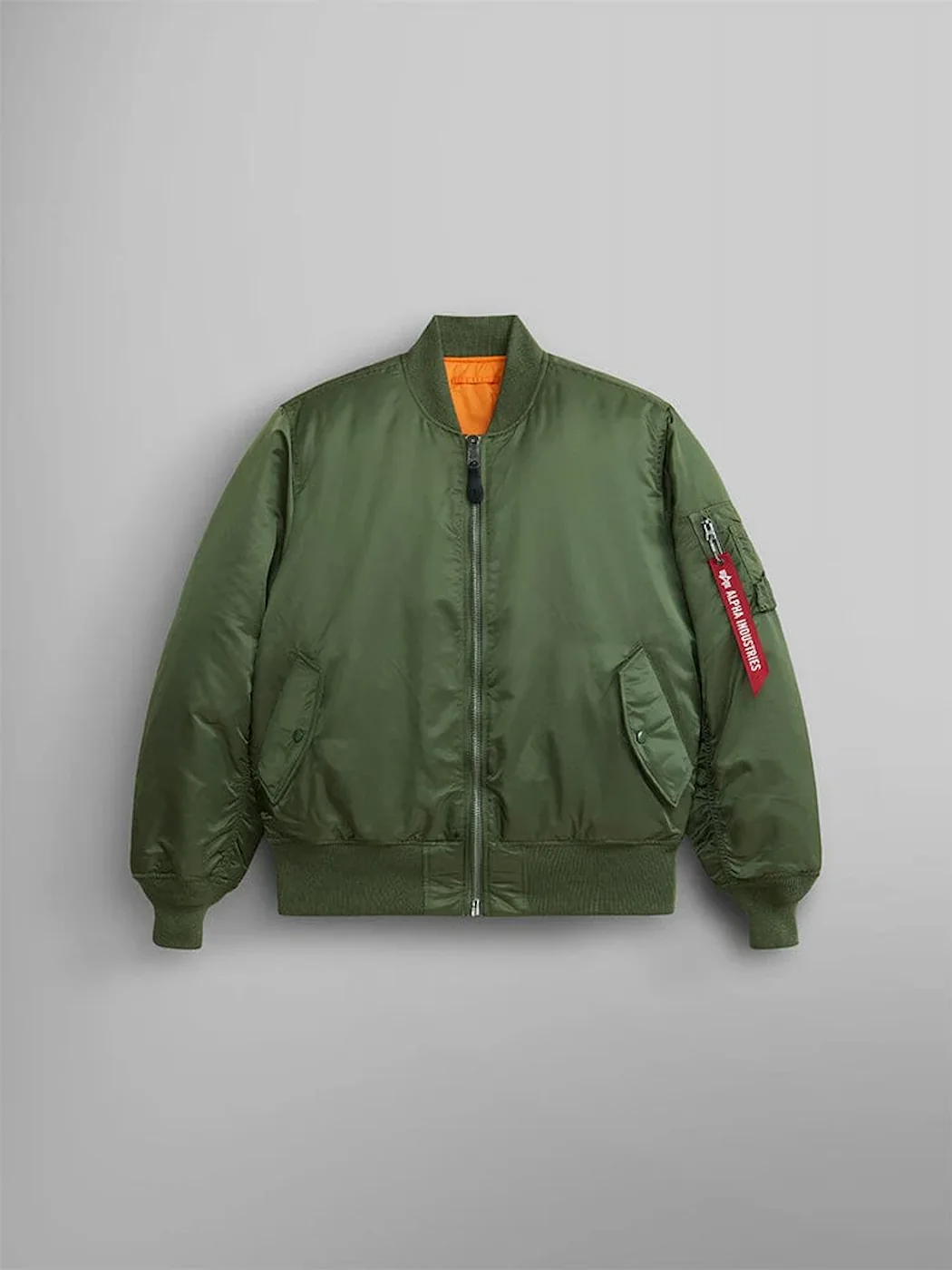 Front of Alpha Industries sage green MA-1 bomber jacket with red sleeve tag.